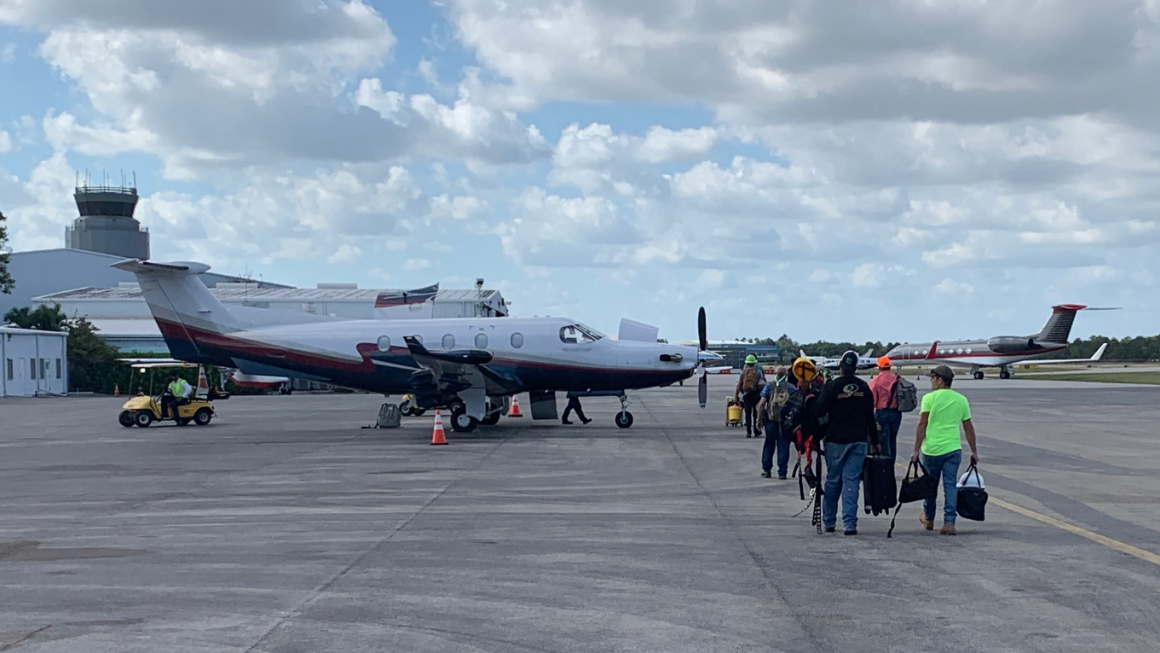 Relief volunteers are walking toward the ATS plane which will be transporting them.